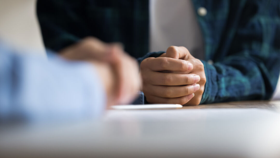 Pflichtverteidigung im Strafverfahren - Hande eines Mandanten auf dem Tisch - rechtlicher Beistand